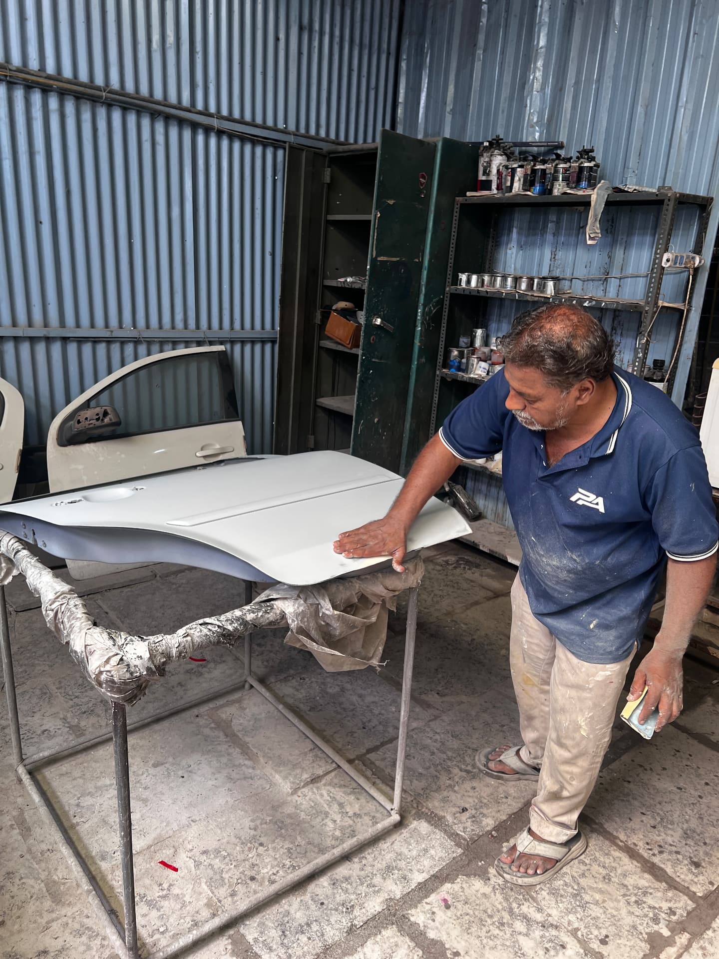 Pune Automotive denting and painting specialist preparing a car bonnet panel for paint